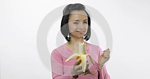 Young beautiful woman with a big banana. Offer bite to viewer