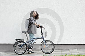 Young beautiful woman with bike over white wall background in a city, Smiling student girl with bicycle smiling outdoor