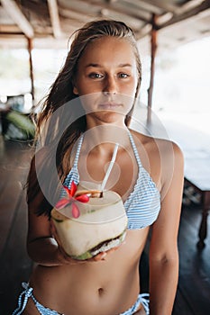 Young beautiful woman drinking coconut water in thai cafe photo