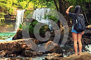 Young beautiful woman in bikini explore waterfall hidden in the tropical jungle on background amazing wild tropical nature