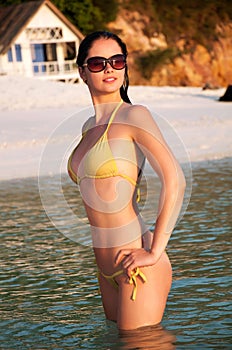 Young beautiful woman in bikini standing in water