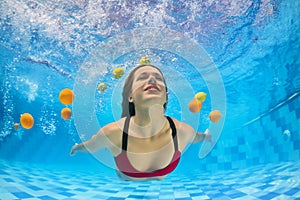 Young beautiful woman in bikini swimming underwater in pool