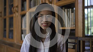 Young beautiful woman biologist is posing in good mood standing in library.