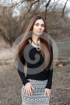 Young beautiful woman in a black blouse and fashion skirt on th