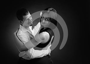 Young beautiful woman in black dress and man in white shirt dancing tango