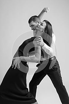 Young beautiful woman in black dress and man in white shirt dancing tango