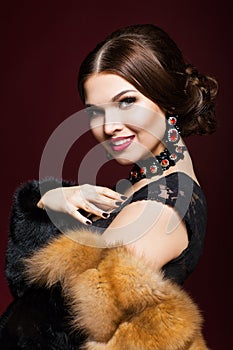 Young beautiful woman in black dress on marsala color background