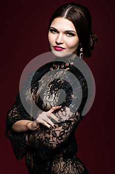 Young beautiful woman in black dress on marsala color background