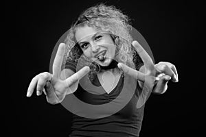 Young beautiful woman with blond curly hair against gray background