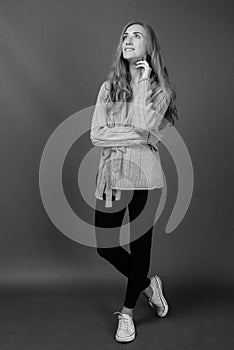 Young beautiful woman with blond hair against gray background