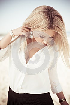 Young beautiful woman blonde poses on a beach