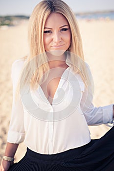 Young beautiful woman blonde poses on a beach