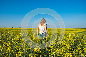 Young beautiful woman blonde is walking along the field