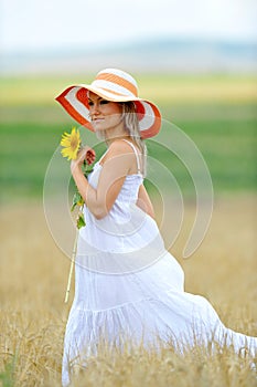 Young beautiful woman on blooming sunflower field
