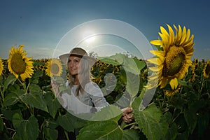 Young beautiful woman on blooming sunflower field