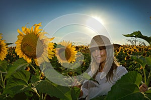 Young beautiful woman on blooming sunflower field