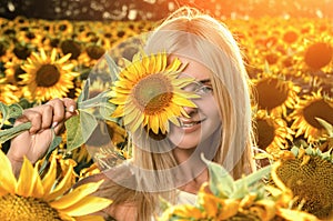 Young beautiful woman on blooming sunflower field