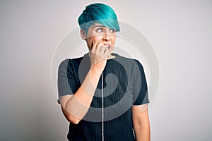 Young beautiful woman with blue fashion hair wearing casual t-shirt over white background looking stressed and nervous with hands