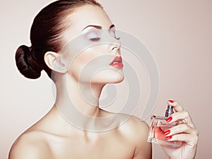 Young beautiful woman with bottle of perfume. Perfect Makeup