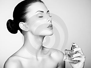 Young beautiful woman with bottle of perfume. Perfect Makeup photo