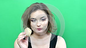 Young beautiful woman with bright evening makeup smoky eyes eating ice cream on a green background