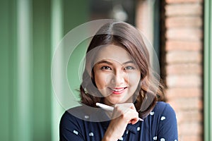 Young beautiful woman in the cafe near the window, thinking and writing something