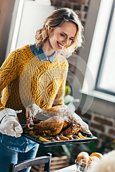 young beautiful woman carrying tray with tasty turkey