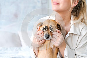 A young beautiful woman in casual clothes hugs and pets her beloved dog sitting