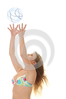 Young beautiful woman catching a beach ball
