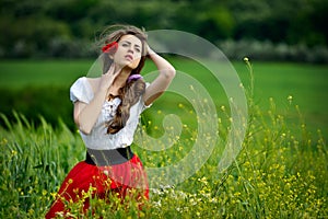 Young beautiful woman on cereal field with poppies in summer