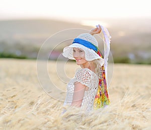 Young beautiful woman on cereal field in summer