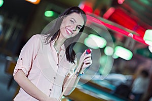 Young beautiful woman chalking the snooker cue and smiling