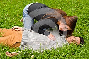 Young beautiful woman checking a handsome young man if he still breathing, cardiopulmonary resuscitation concept, in a