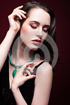 Young beautiful woman with closed eyes on red marsala background