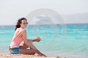 Young beautiful woman with coffee on the beach during tropical vacation.