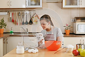 Young beautiful woman is cooking in the kitchen.