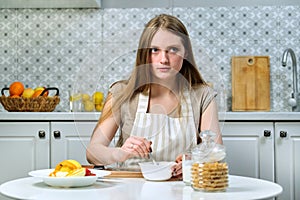 Young beautiful woman cooks tasty wholesome diet food at home