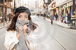 Young beautiful woman covering face with woolen scarf