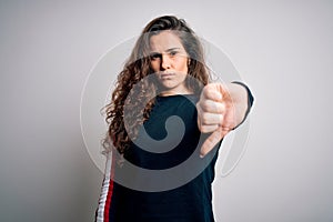 Young beautiful woman with curly hair wearing casual sweater over isolated white background looking unhappy and angry showing