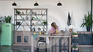 Young beautiful woman dancing in kitchen and taking banana, joyful and cheerful female at home during morning