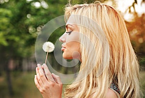 Young beautiful woman with a dandelion