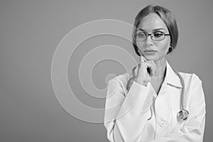 Young beautiful woman doctor with blond hair in black and white