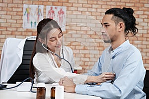 Young beautiful woman doctor is health examining a male patient