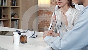 Young beautiful woman doctor is health examining a male patient.