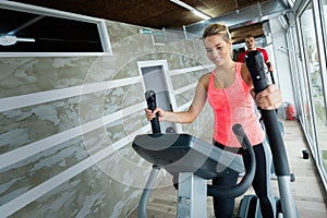 Young beautiful woman doing cardio in gym