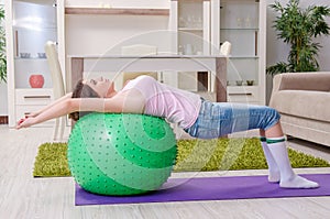 The young beautiful woman doing exercises at home