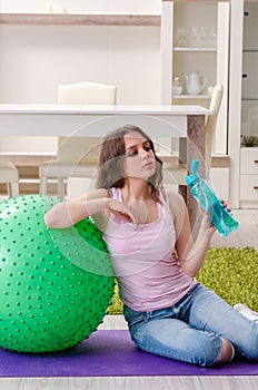 The young beautiful woman doing exercises at home