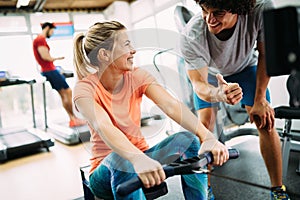 Young beautiful woman doing exercises with personal trainer