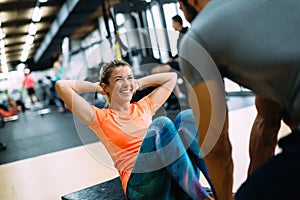 Young beautiful woman doing exercises with personal trainer