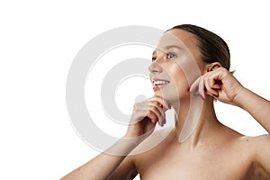 Young beautiful woman doing facial massage according to massage lines against white studio background. Copy space.
